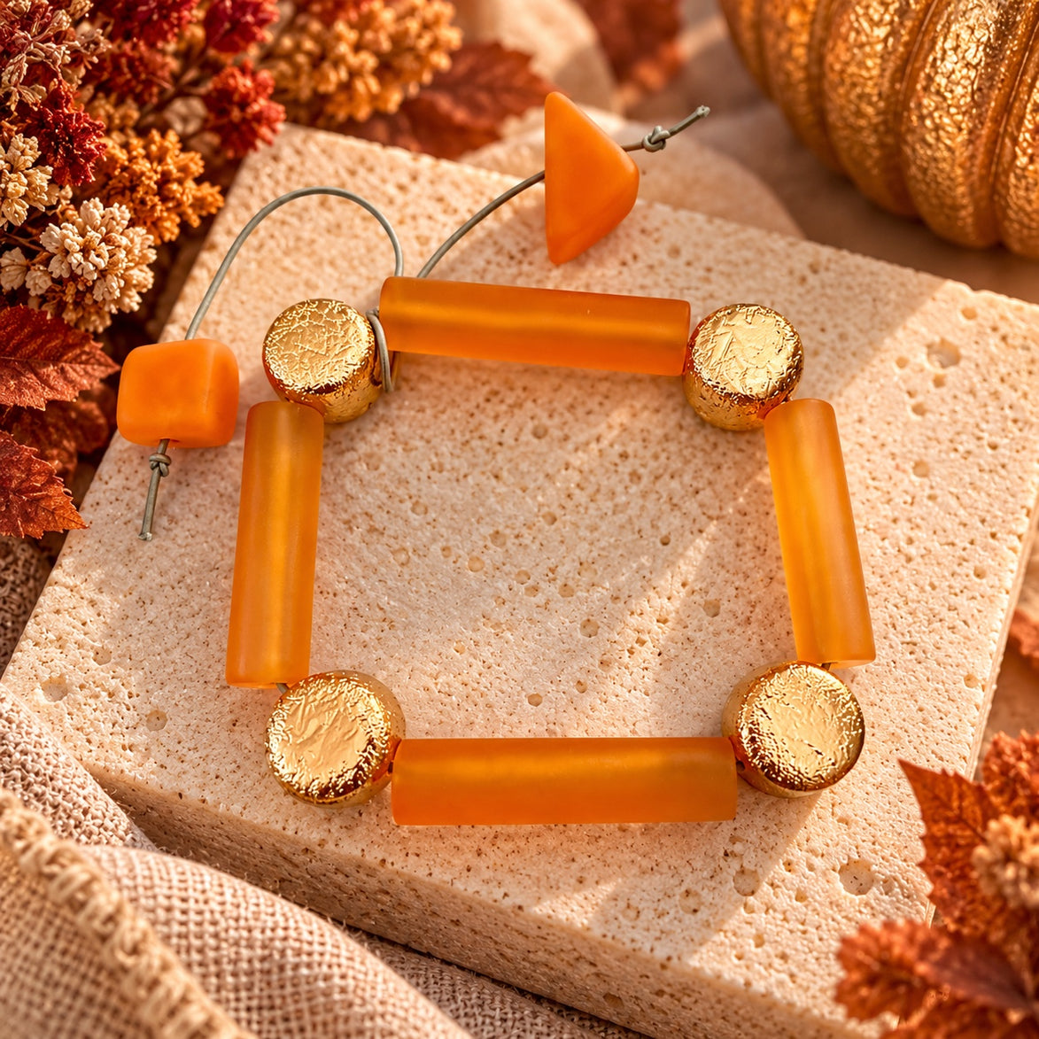 Amber-orange and textured gold-tone geometric bracelet