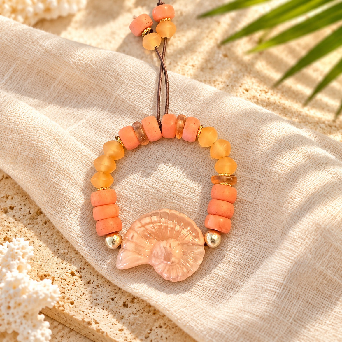 Coral peach and amber bracelet with pale pink spiral shell centerpiece