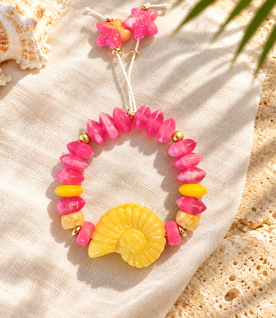 Pink beaded bracelet with yellow spiral shell and starfish cord ends